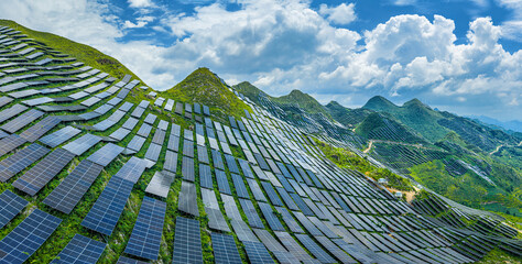 Massive solar panel farm installed on green mountain slopes for renewable energy production under a...
