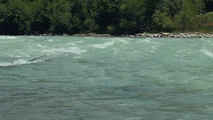 Fototapete Wald Fluss Powerful turquoise mountain river with rapids flowing along a forest bank.  © VeNN