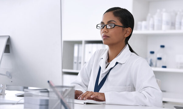 Woman, science and reading in laboratory by computer, review or thinking for solution at pharmaceutical company. Person, pc and innovation for medicine, drugs or research with medical journal on web