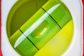 A macro view of a green spirit level vial. The air bubble is perfectly centered between the black marks, indicating a level surface for construction and DIY projects