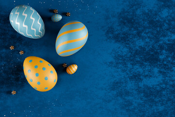 Colorful easter eggs with blue and orange patterns on a blue background. 3d rendering