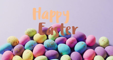 Image of happy easter text over colourful easter eggs on purple background