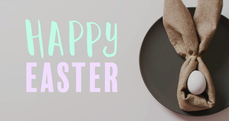 Image of happy easter text over easter eggs in cloth on white background