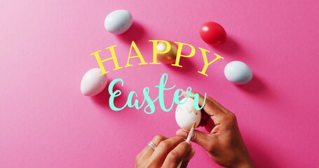 Image of happy easter text over woman painting colourful easter eggs on pink background