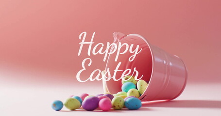 Image of happy easter text over colourful easter eggs and pink bucket on pink background
