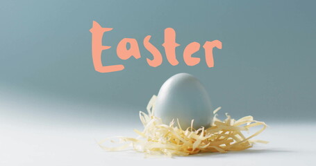 Image of easter text over blue easter egg in hey on blue background