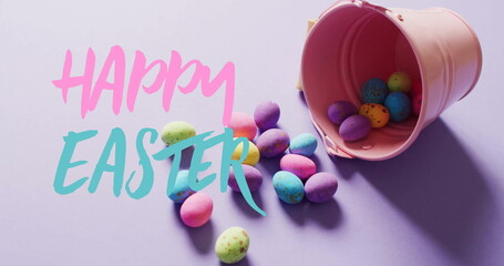 Image of happy easter text over colourful easter eggs on purple background