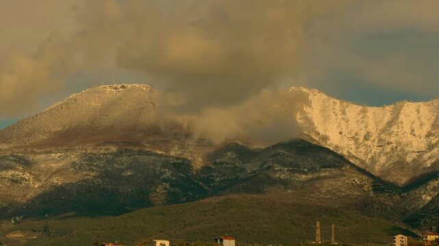 Timelapse of Mount Dajti with dramatic clouds moving over snow-dusted peaks, showcasing changing light and atmospheric mountain scenery in Albania.