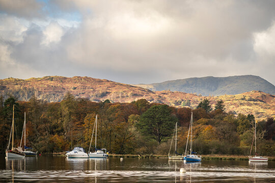 Sailboats on the water of Lake Windermere on a sunny autumn morning in the Lake District national park.