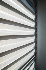 Obraz premium Modern window with zebra roller blinds and chain mechanism detail, contemporary apartment interior and daylight control concept