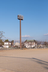 放課後の静かな土のグラウンドとサッカーゴール、日本のアニメ風の風景（部活・ノスタルジー）