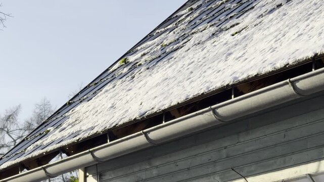 rain gutter with thawing snow and ice