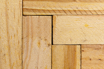 Macro shot featuring the natural texture and grain of light-colored wooden planks arranged in vertical and horizontal patterns. Ideal for rustic or carpentry design themes