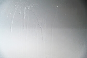 A close-up view of a gray painted surface featuring vertical liquid streaks and drips, creating a grunge industrial background for design projects