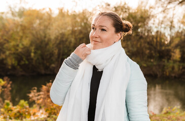 Freckled woman walking by river on an early spring day.
