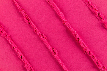 cosmetic background of bright pink blush with a pattern of the sample. Beautiful texture of crimson blush. parallel stripes of the drawing. top view.