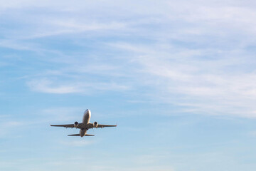 Fototapeta premium Passenger airplane taking off from batumi international airport over mountain landscape with blue sky, barbed wire fence and copyspace, concept of travel, aviation, freedom