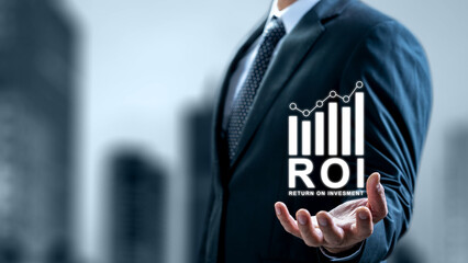 Businessman in a suit holds a virtual ROI graphic with a rising bar chart, symbolizing financial success, investment growth, and profitable business strategies in a corporate setting
