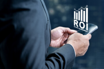 Professional in a suit using a smartphone to monitor return on investment. Digital bar chart ROI graphic overlay representing business growth, financial analytics, and profit tracking