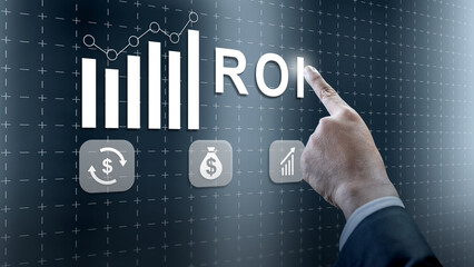 A businessman points to ROI on a futuristic digital screen featuring financial icons and charts representing business growth and investment success