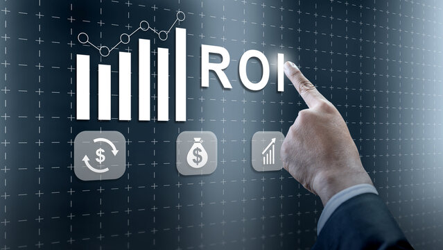 A businessman points to ROI on a futuristic digital screen featuring financial icons and charts representing business growth and investment success - Powered by Adobe