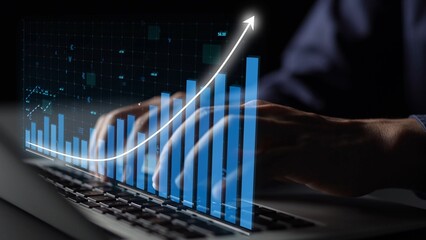 Close-up of hands typing on a laptop, overlaid with a rising graph, symbolizing business growth and data analysis in a contemporary workspace setting. Copula