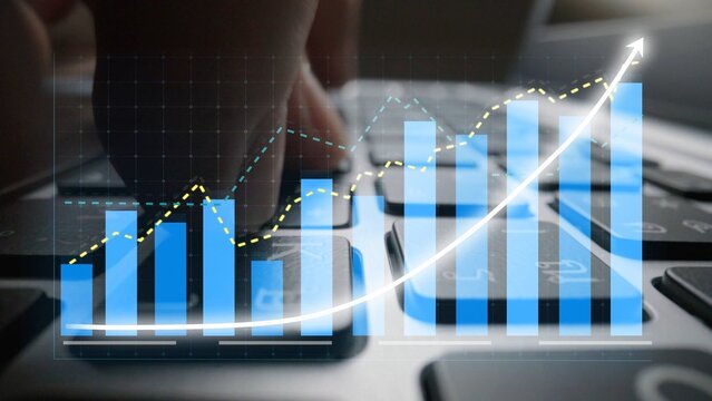 A close-up view of a businessman hands typing on a laptop, with transparent financial graphs highlighting growth, reflecting modern data analysis and market dynamics. Copula - Powered by Adobe