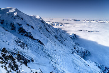 Obraz premium Majestic snow-capped Alpine peaks in winter above the clouds, Chamonix-Mont-Blanc, France.