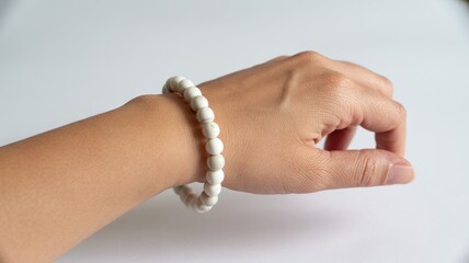 Elegant woman's hand with white beaded bracelet on wrist