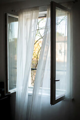 Open window, wind blowing white curtains