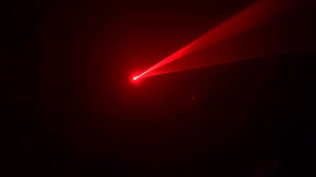 Red laser beam cutting through darkness, creating a striking visual effect. Ideal for technology, science, and creative projects