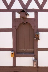 Half timbered wall with small wooden birdhouse detail
