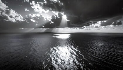 Ocean surface reflecting sun rays through dark clouds