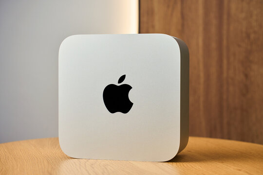 Apple Mac Studio Max desktop computer on wooden desk. High performance professional workstation from Apple on table