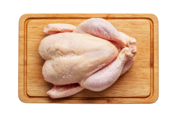 Whole raw chicken resting on a wooden cutting board with pale skin, tucked wings, and intact body ready for preparation isolated on transparent background.
