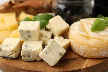 Different types of cheese and other snacks on table, closeup