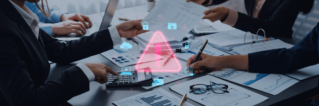 Business team collaborating on financial report analysis with digital icons and warning symbol highlighting security concerns and data protection strategies Trope. - Powered by Adobe