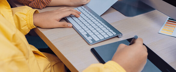 A modern creative workspace with two professionals engaged in digital art projects, utilizing graphic tablets and computers, showcasing teamwork and innovative ideas. SACTR