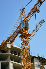 high-rise construction crane against the blue sky