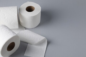 Toilet paper rolls on light grey background, closeup. Space for text