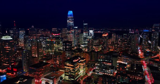 Footage over the gorgeous dazzling panorama of San Francisco, CA, USA at night. Heading to the wonderful Salesforce Tower lit blue at top.