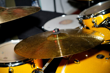 Golden cymbal gleaming on drum kit in music studio