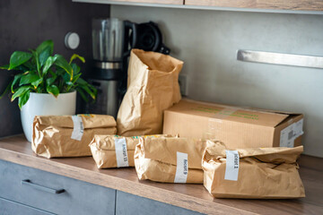 Meal kit ingredients sorted by recipe and placed on the kitchen counter. Concept of convenient...