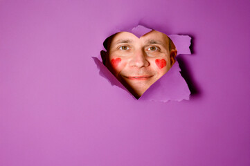Male Portrait Through Heart-Shaped Hole on Purple Background. Copy space for Valentine greetings © Evgeniya