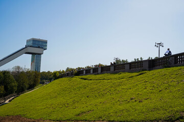 Ski jump standing tall in Vorobyovy Gory park with Moscow skyline behind. The ski jump rises in the...