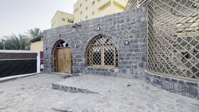 Exterior view of Al Ghars Well in Madinah, featuring historic stone architecture, arched doors and sacred surroundings linked to Islamic heritage and spiritual history.