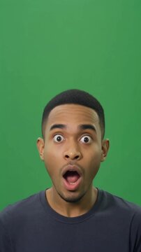 Surprised young man with wide open mouth on green screen background for expressive reaction videos emotional scenes and viral content