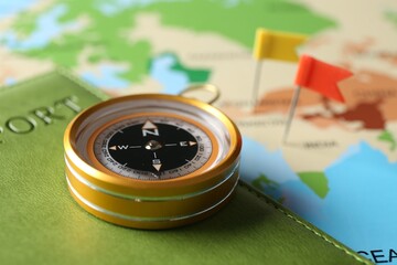 Journey. Compass, flag push pins and passport on world map, closeup © New Africa