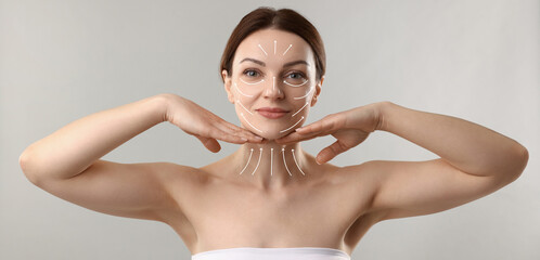 Beautiful woman with lifting lines on face and neck against grey background. Skin care for...