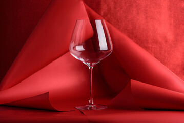 Wine Glass for Red Wine on Sculptural Red Background. Artistic Still Life with Transparency and Form